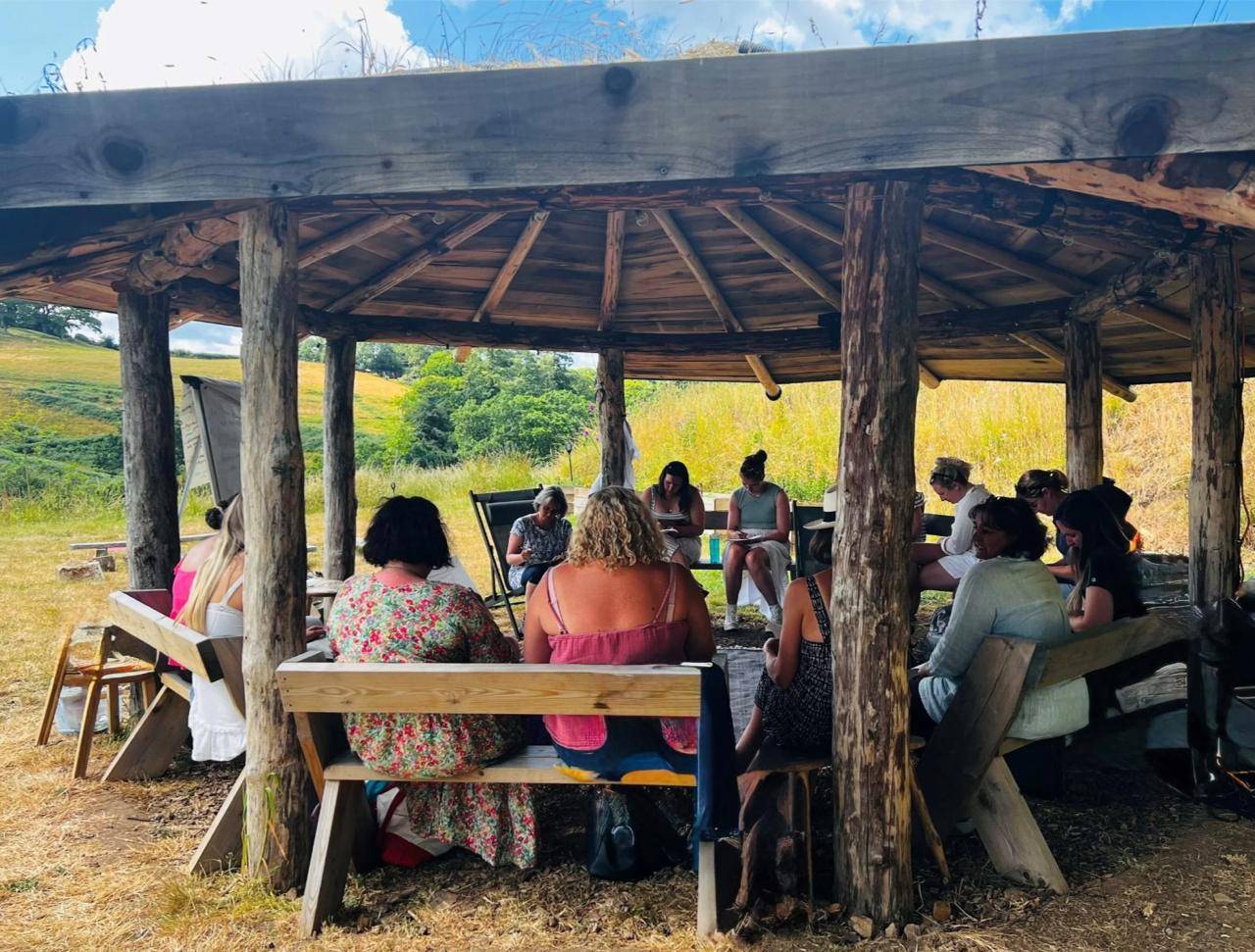 Group gathering under the roundhouse at Field of Possibility